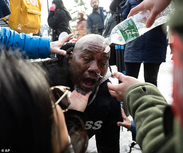 Photographer King Demetrius Pendleton has his eyes flushed after being hit with chemical irritants amid ongoing protests in the Minnesota city on Wednesday