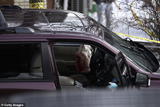 Police tape surrounds the SUV in which a 37-year-old woman was shot by ICE earlier today