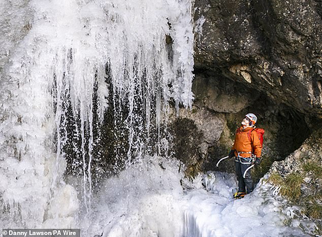 Lost Earth Adventures instructor Mick Ellerton climbs a frozen waterfall in Gordale Scar near Malham Cove in the Yorkshire Dales National Park on Wednesday as ice warnings remain in place