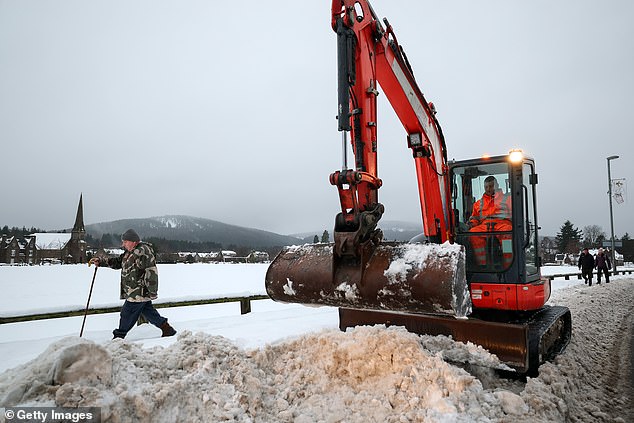 Workers clear pavements in Aboyne, Aberdeenshire, on Wednesday morning following heavy snowfall