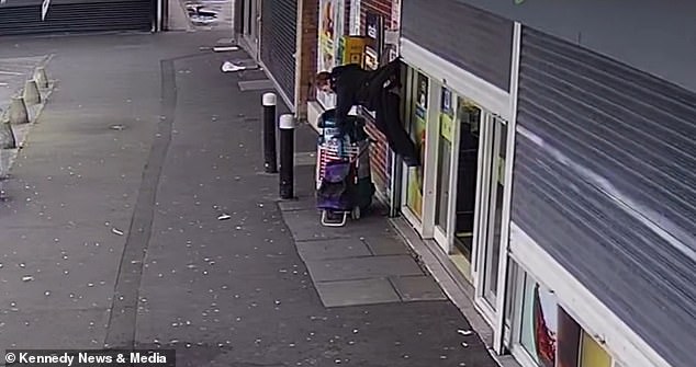 Pictured: The woman holds her shopping trolley as she is rotated upside down in the viral video