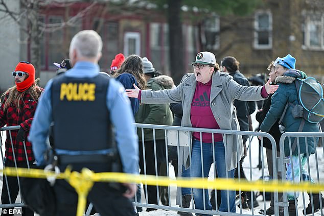 A person yells at Minneapolis police officers as they respond to the scene where Good was shot and killed by ICE agents