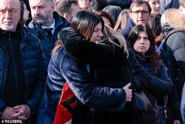 Mourners hug each other during the funeral of 16-year-old Riccardo Minghetti