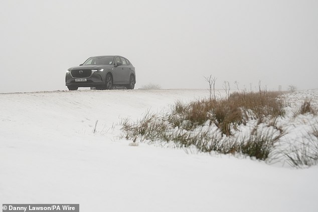 A car on the A57 Snake Pass in the Peak District today as wintry weather continues in the UK
