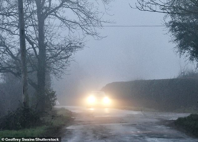 A motorist drives along a country lane in the fog in Dunsden, Oxfordshire, this morning