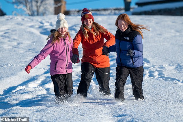 Daily Mail reporter Claire Elliot plays with her children in the heavy snow in Aberdeenshire