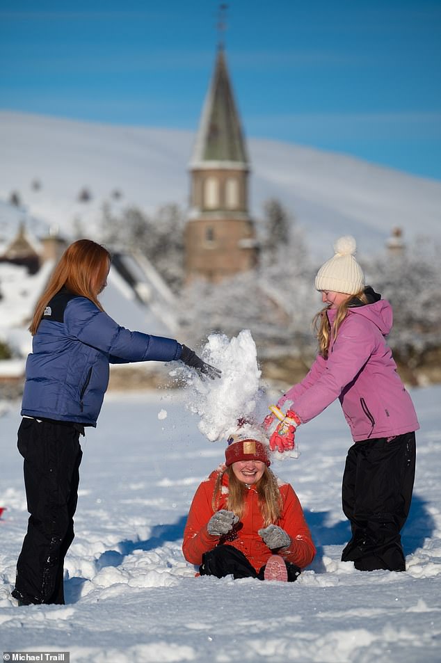 Daily Mail reporter Claire Elliot plays with her children in the heavy snow in Aberdeenshire