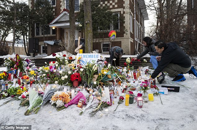 People tend to a memorial for Renee Nicole Good near the site of her shooting on January 8, 2026 in Minneapolis
