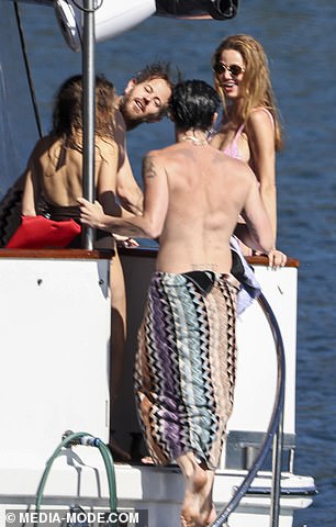 Dina was seen smiling and giggling as she watched her younger party companion bare himself to the world, but chose to keep her own swimwear on