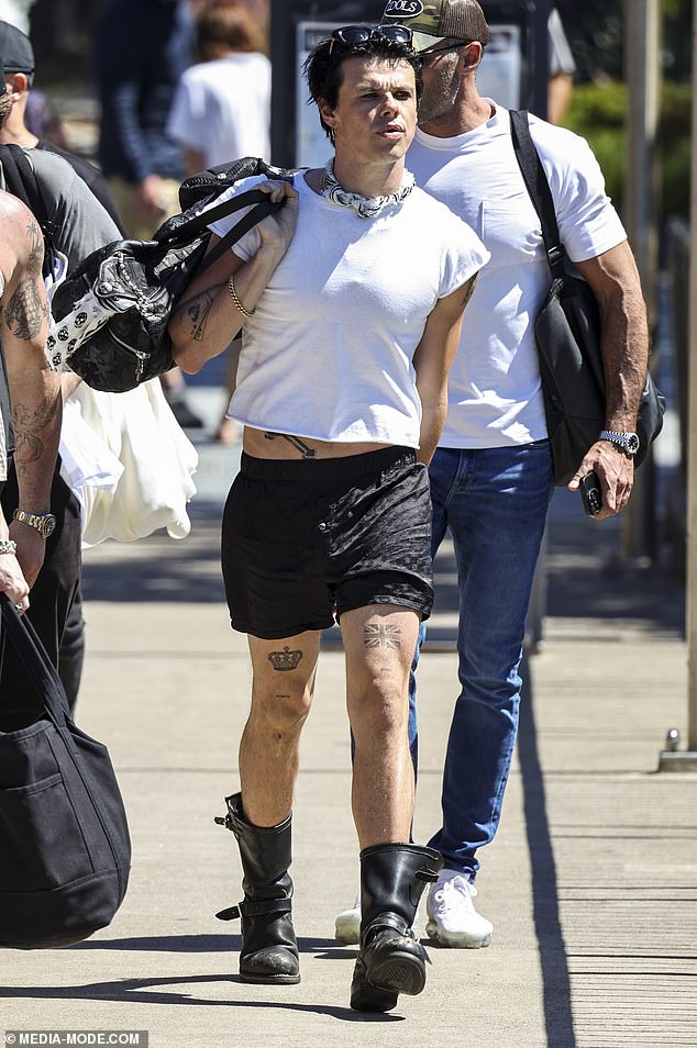 He arrived at the dock in a white cropped T-shirt, black short-shorts and leather combat boots
