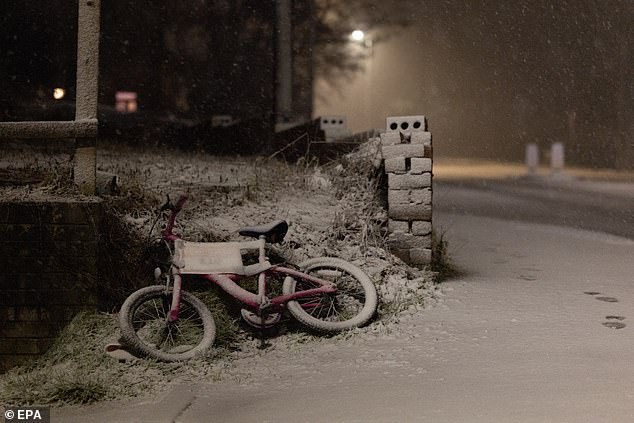 A bicycle is abandoned in the snow on Thursday night in Ruthin, Wales