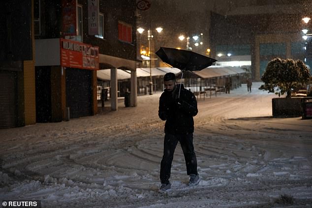 A man's umbrella is turned upside down by the wind in Walsall on Thursday night