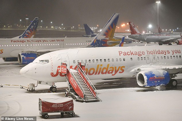 Birmingham Airport, pictured on Thursday night, confirmed it suspended use of its runway operations due to 'heavy snow'