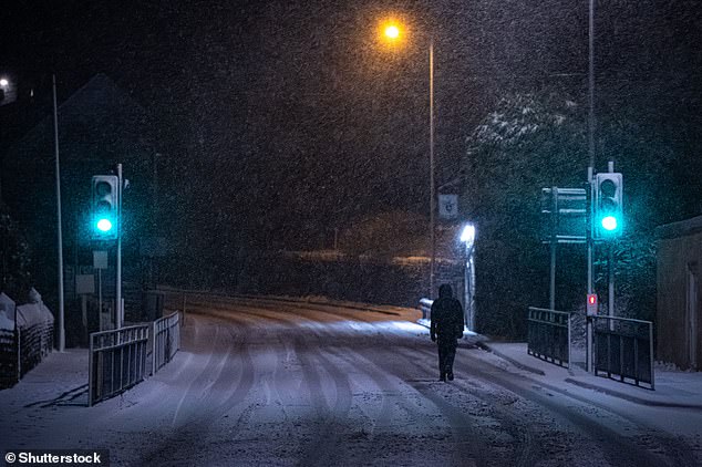 A man crosses the road on a steep road in the town of Mossley in Tameside, Greater Manchester.