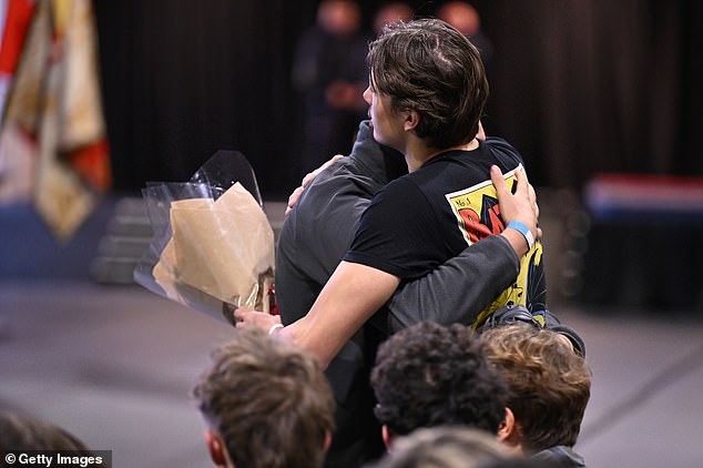 Mourners embrace as they attend a memorial ceremony in tribute to victims of the Crans-Montana bar fire on January 9, 2026 in Crans-Montana