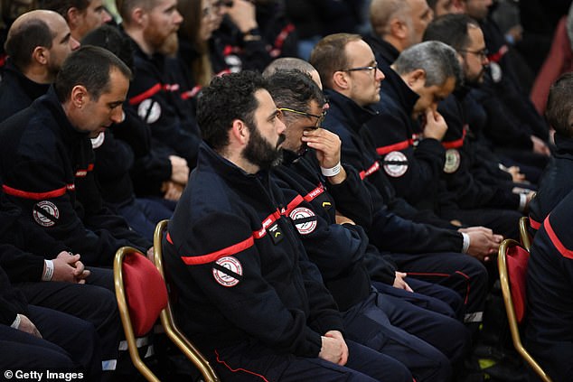 Members of the emergency services react as they attend a memorial ceremony in tribute to victims of the Crans-Montana bar fire on January 9, 2026 in Crans-Montana