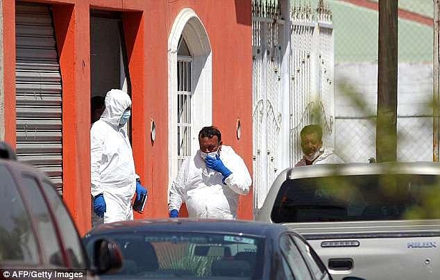 Jalisco Institute of Forensic Sciences staff work at a house connected to the kidnapping and murder of three university students