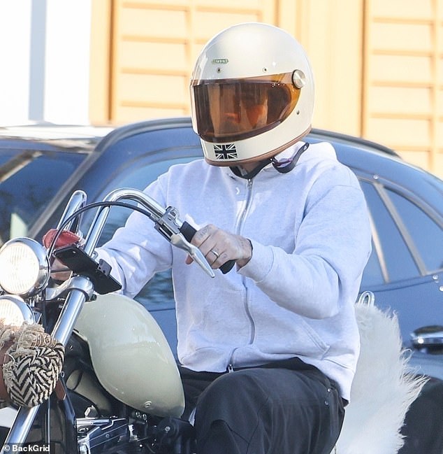 Brooklyn was driving a Harley Davidson Chopper motorcycle, featuring a fluffy seat, as he peered out from behind an orange-tinted visor