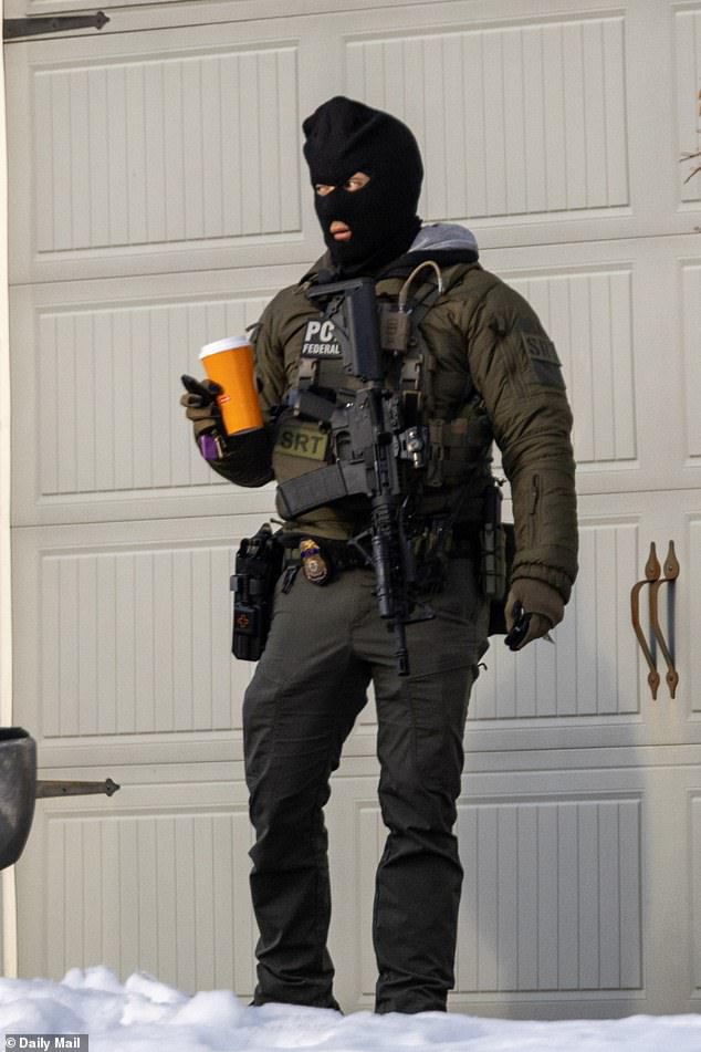 One agent with an assault rifle strapped to his chest took a coffee break in front of the garage