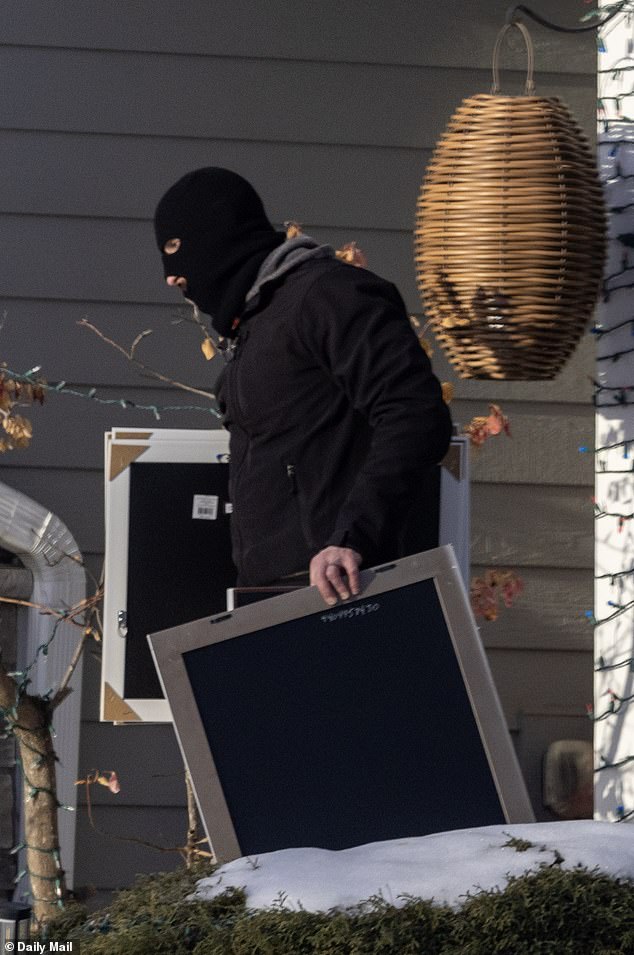Another balaclava-wearing agent brought out large picture frames
