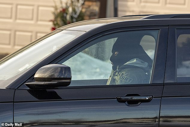 An agent in a full-face black balaclava drove a black Jeep SUV from the Ross family's garage