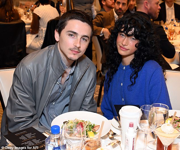 Chalamet additionally donned a dark gray jacket as well as a gray-striped shirt underneath that was partially unbuttoned at the top