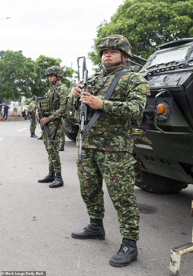 A military guard at La Parada border crossing in Cucuta, Colombia, observing the flow of civilian traffic crossing the bridge from Venezuela