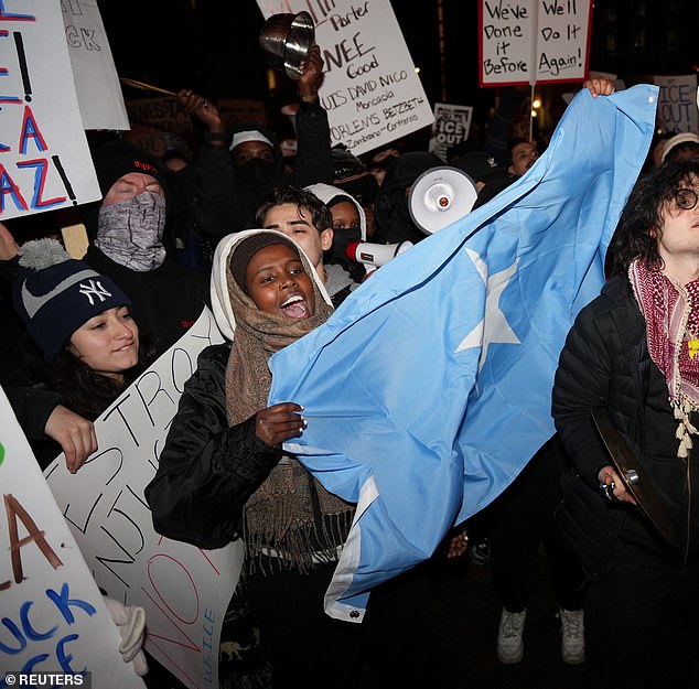 A protestor holding the flag of Somalia was seen marching as part of a massive demonstration against ICE
