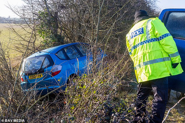 Police inspect a car that skidded off the road in Peterborough on Saturday morning