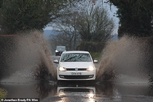 Cars go through surface water on  Row Lane near Emmer Green in Berkshire on Friday morning