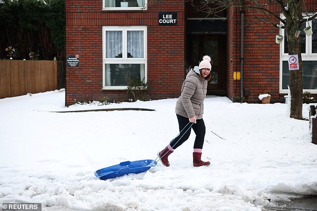 A woman pulls a sledge on the snow in Walsall on Friday morning after Storm Goretti hit the UK