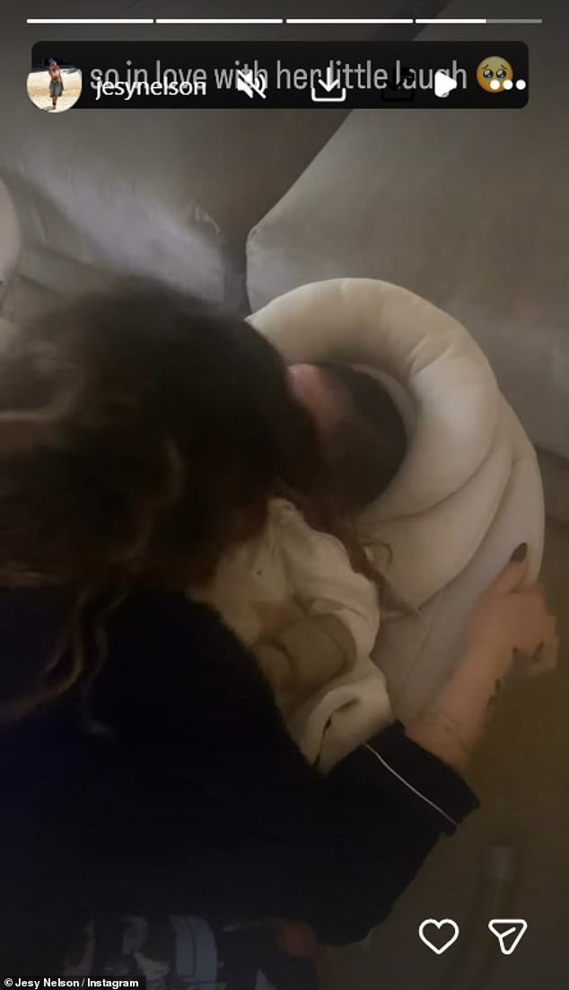 In the clip, Jesy coos at her daughter who squeels and laughs in response while tucked up in a baby bouncer chair