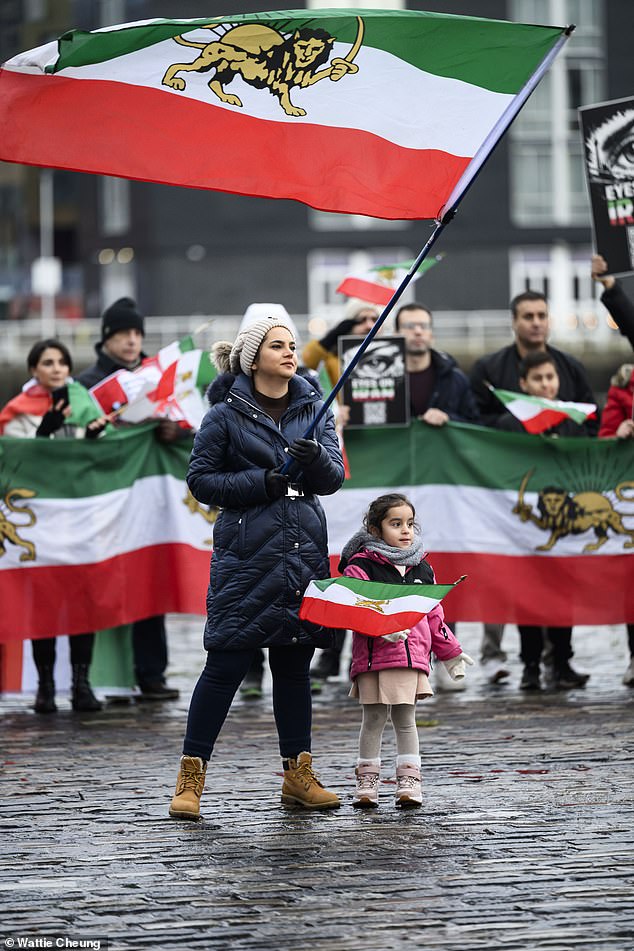 A mother and young daughter attend a protest for Iranians in Glasgow, Scotland on Saturday