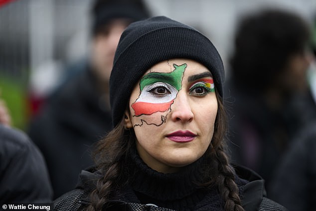 A woman with a map of Iran painted on her face joins a protest in Glasgow on Saturday