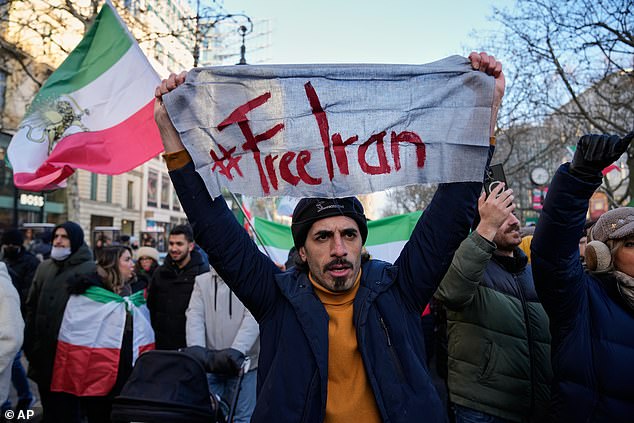 A man holds a sign reading 'Free Iran' during a protest in the German capital, Berlin, on Saturday
