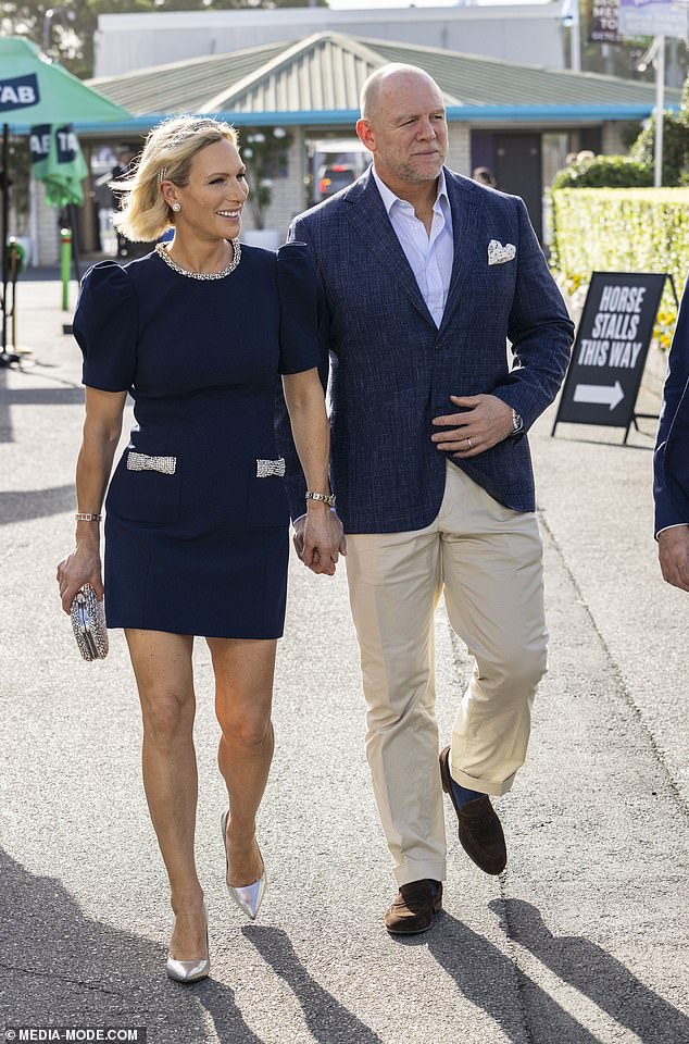 Her husband Mike looks smart in a navy blazer, cream trousers and brown suede shoes