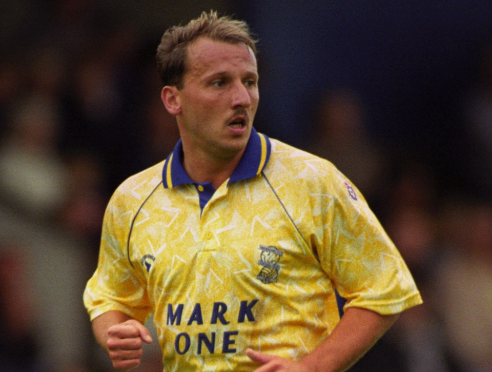 A soccer player in a yellow and blue uniform running on a green field.