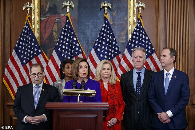 The White House has been pushing to soften the descriptions of Trump's impeachments at the Smithsonian's museums. Former Speaker of the House Nancy Pelosi is pictured with members of Congress during Trump's impeachment in December 2019