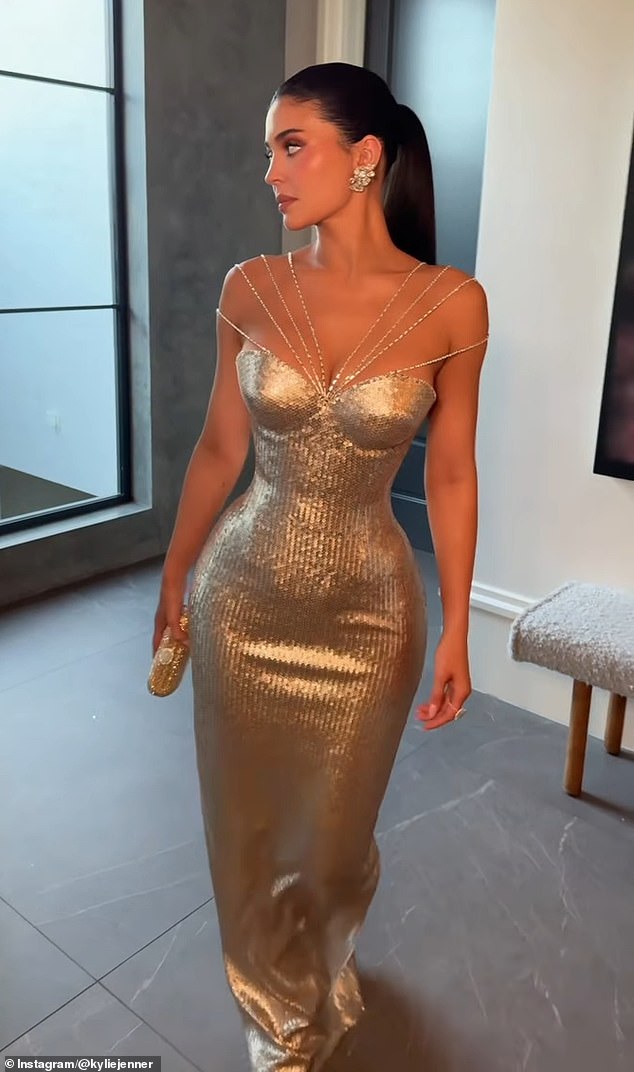 Jenner wowed her nearly 400 million followers as she strutted down a hallway in a glitzy gold gown that showed off her famous curves