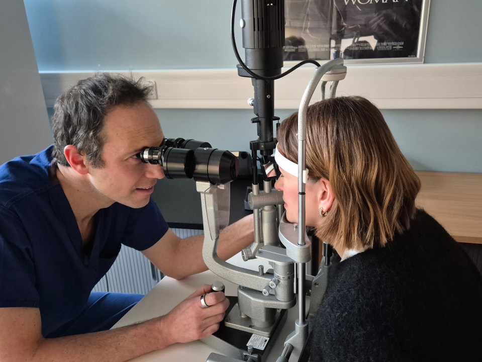 Ophthalmologist Harry Petrushkin examines patient Nicki Guy with an optical instrument.