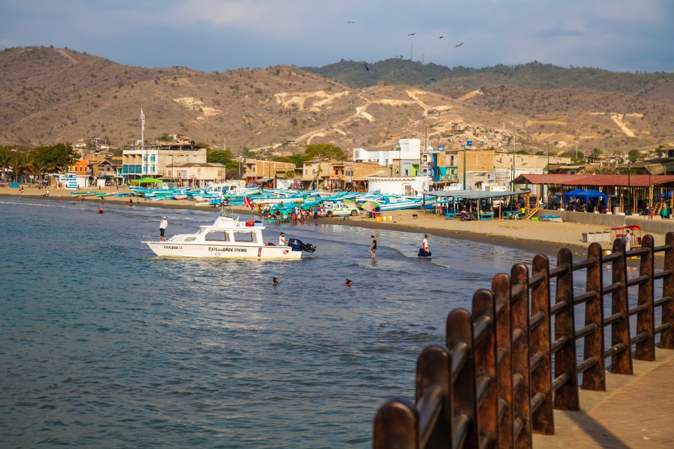 Dive boat and beach scene on the Ecuador coast. Puerto Lopez, Manabi, Ecuador