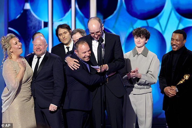 Jack Thorne, center, flanked by Stephen Graham, center left, and Owen Cooper, as they appear with other cast members of Adolescence after winning the award for best limited series