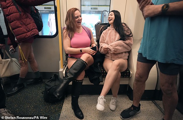 Two women sit on a Circle line train as they take part in the No Trousers Tube Ride yesterday