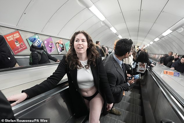 A woman stands on an escalator during the No Trousers Tube Ride in London yesterday