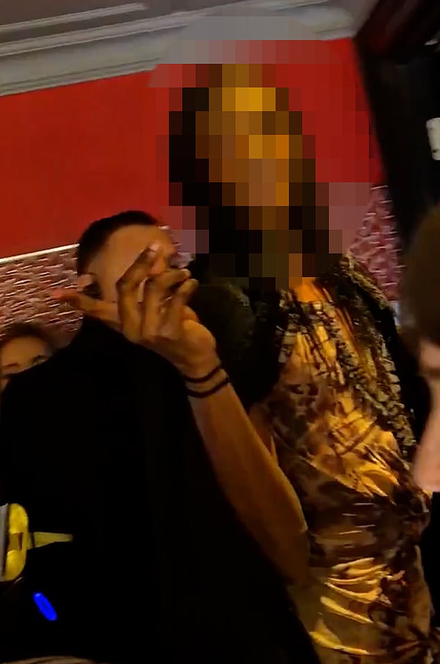 But as they are being escorted out, one can be heard telling one woman: 'I'll show you what a man is'.