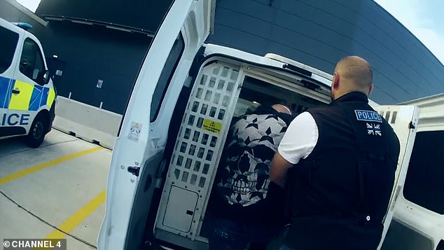 Holub is put in a police van at Luton Airport before being taken away by officers for questioning