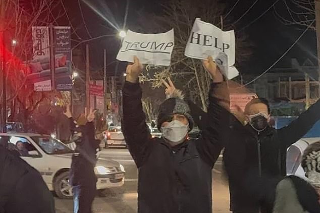 A protester in Tehran holding up a handwritten note asking Donald Trump for help in supporting protesters against government repression