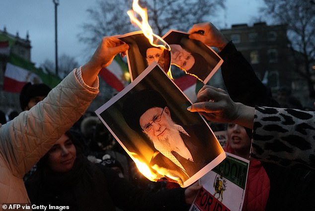 Protestors burn images of Ayatollah Ali Khamenei during a rally held in Solidarity with Iran's Uprising, organised by The national Council of Resistance of Iran, on Whitehall in central London