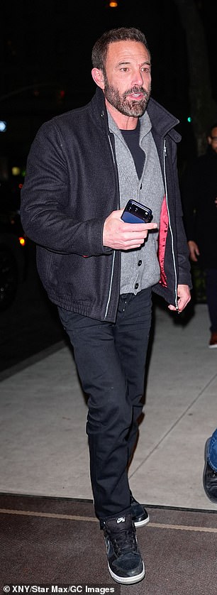 He layered up in a grey cardigan, black T-shirt, matching jeans and Nike high-tops