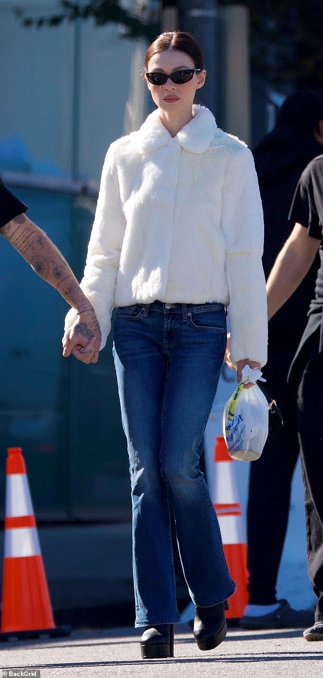 She teamed it with blue jeans and heeled boots